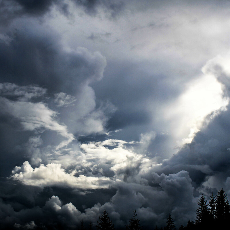 brightly shining sun blazing through dark stormy clouds 